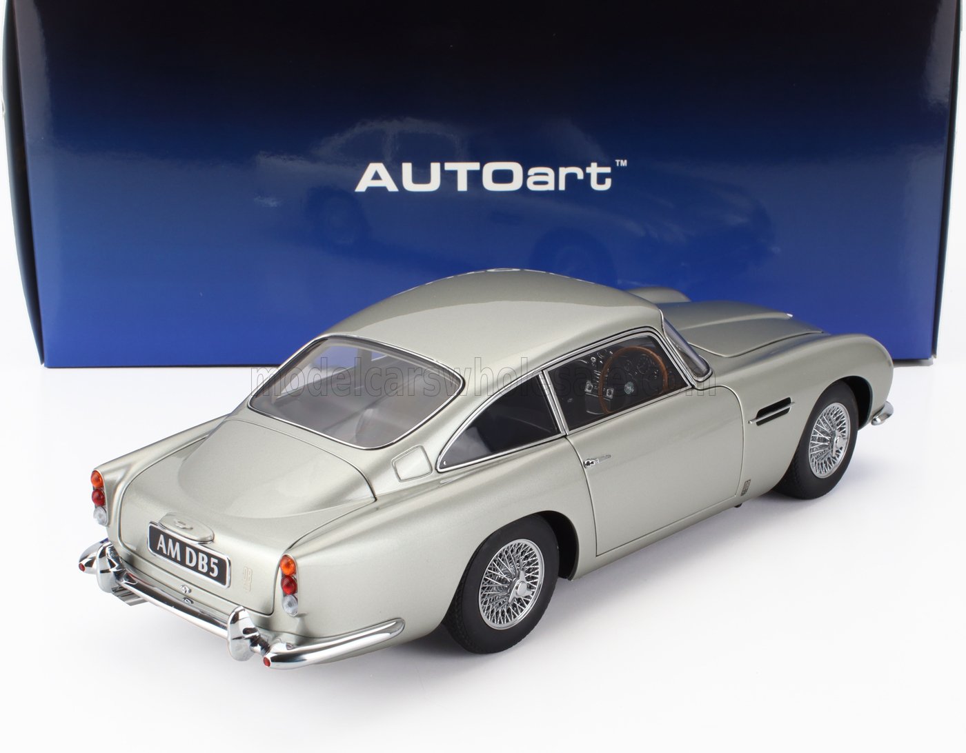Modellino Aston Martin DB5 color argento con dettagli cromati, esposto su scatola AUTOart, disponibile tramite Vroomi.