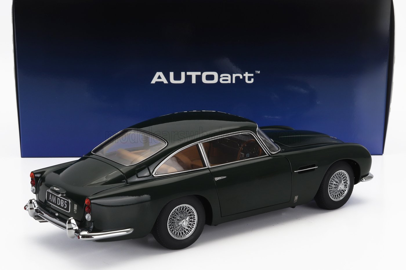 Modellino Aston Martin DB5 verde scuro con cerchi a raggi, esposto su una scatola blu AUTOart, disponibile su Vroomi.