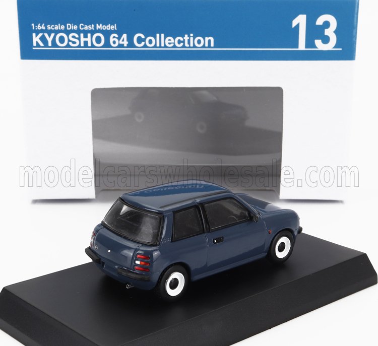 Modellino Kyosho 64 Collection in blu scuro, scala 1:64, esposto con confezione, ora disponibile su Vroomi.