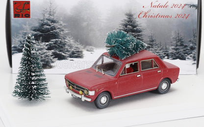 Modellino di auto vintage rossa con un alberello di Natale in miniatura sul tetto, sfondo innevato con pini, disponibile su Vroomi.