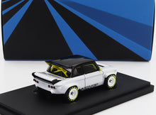 White and black classic model car with yellow accents on display stand, now offered through Vroomi