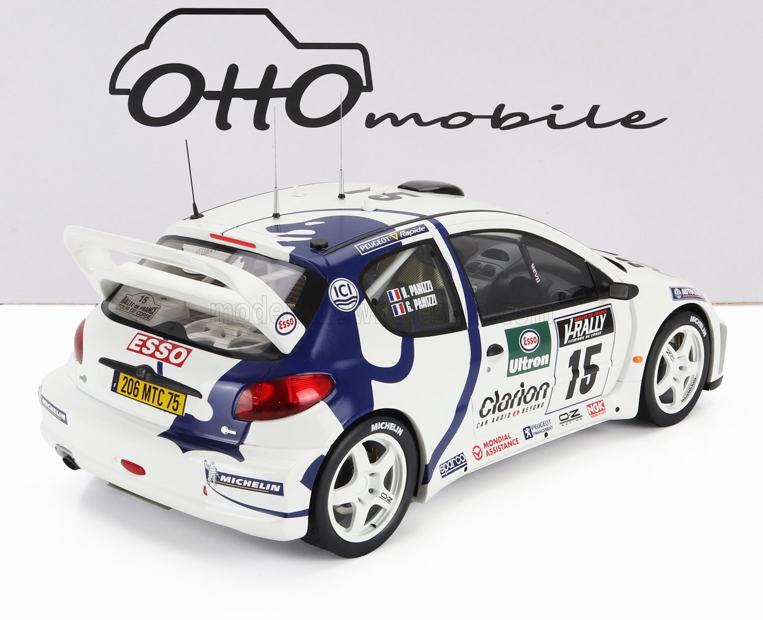 Modellino di auto da rally Peugeot bianca e blu con adesivi degli sponsor, ora disponibile su Vroomi.