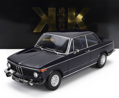 Modello classico di berlina BMW 1602 nera con finiture cromate, in mostra su uno sfondo nero e oro in scala K, disponibile su Vroomi.