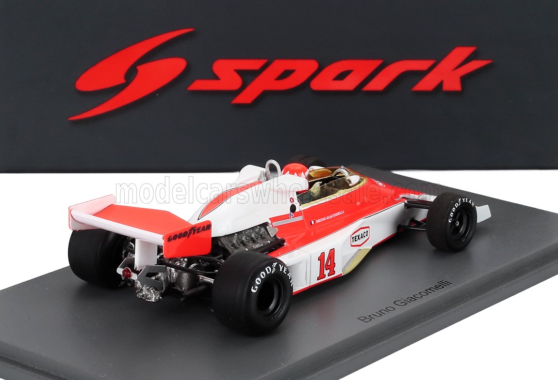Modellino di auto da Formula 1 Bruno Giacomelli vintage rosso e bianco in scala 1/18 con pneumatici Goodyear, esposto su base grigia con logo Spark, disponibile presso Vroomi.