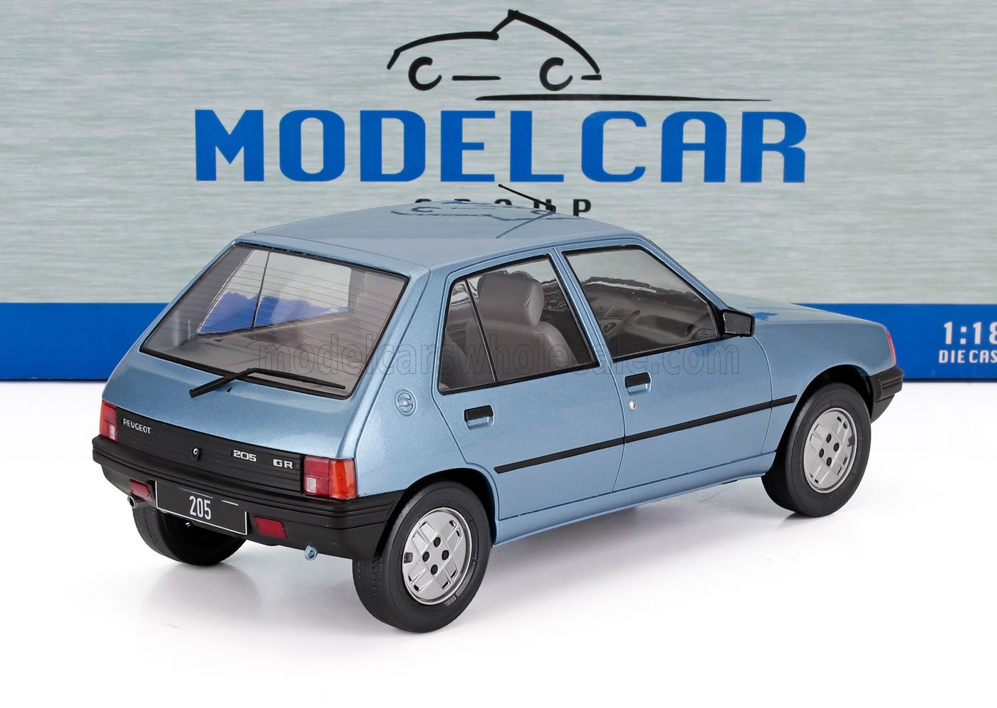 Modello in scala 1:18 della Peugeot 205 GR hatchback blu con interni dettagliati, disponibile su Vroomi.