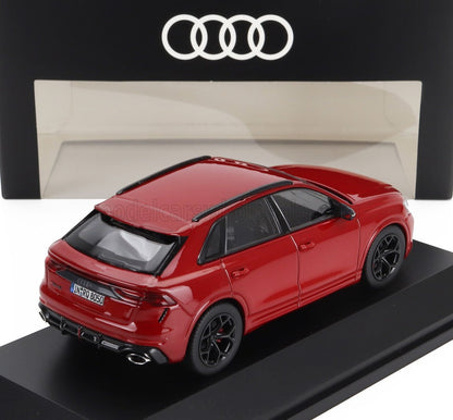 Modellino di Audi RS Q8 rossa su supporto nero con logo Audi sullo sfondo, disponibile anche tramite Vroomi.