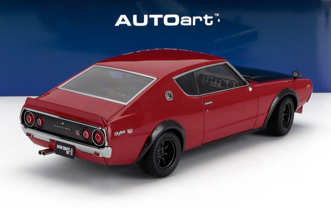 Modellino di Nissan Skyline 2000 GT-R rossa con parafanghi neri, presentato da AUTOart e disponibile su Vroomi.