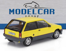 Modellino in scala 1/18 di Opel Corsa gialla e nera esposto con sfondo Model Car Group, disponibile su Vroomi.