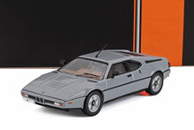 Gray BMW M1 classic sports car model against orange and black background, now available on Vroomi