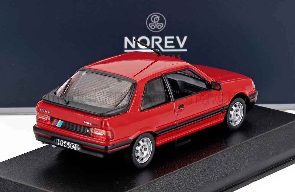 Modellino di Peugeot 309 GTI rossa su espositore con logo Norev, disponibile sulla piattaforma Vroomi.