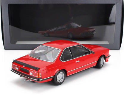 Modellino in scala di una BMW 635 CSi rossa con spoiler nero davanti alla teca espositiva, disponibile su Vroomi.