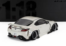 Modellino Toyota GR86 in scala 1:18 bianco con kit carrozzeria larga e ruote nere, disponibile su Vroomi.