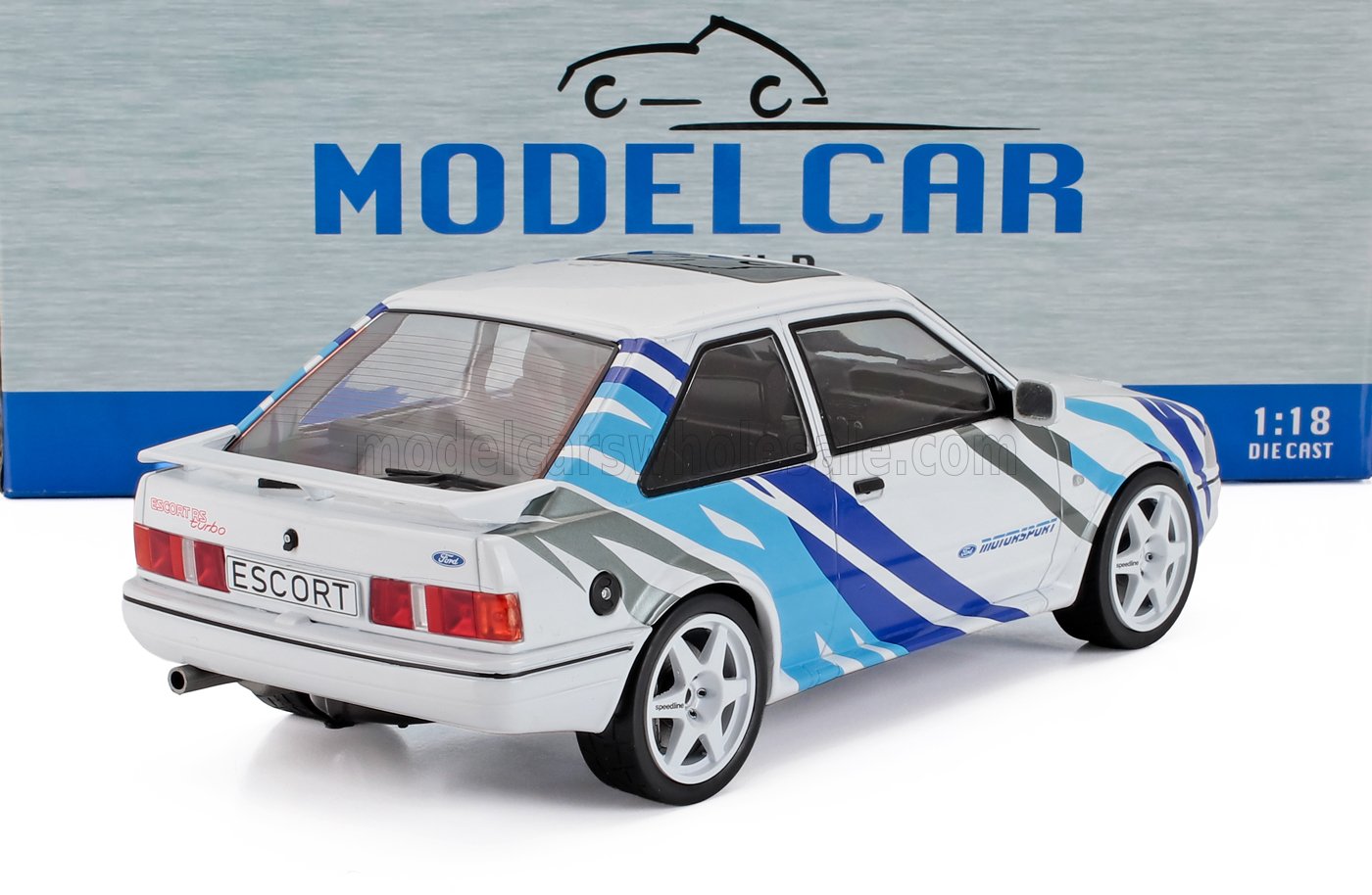 Modellino in scala 1:18 della Ford Escort RS Turbo bianca con strisce blu e grigie da corsa, visto dal retro, disponibile su Vroomi.