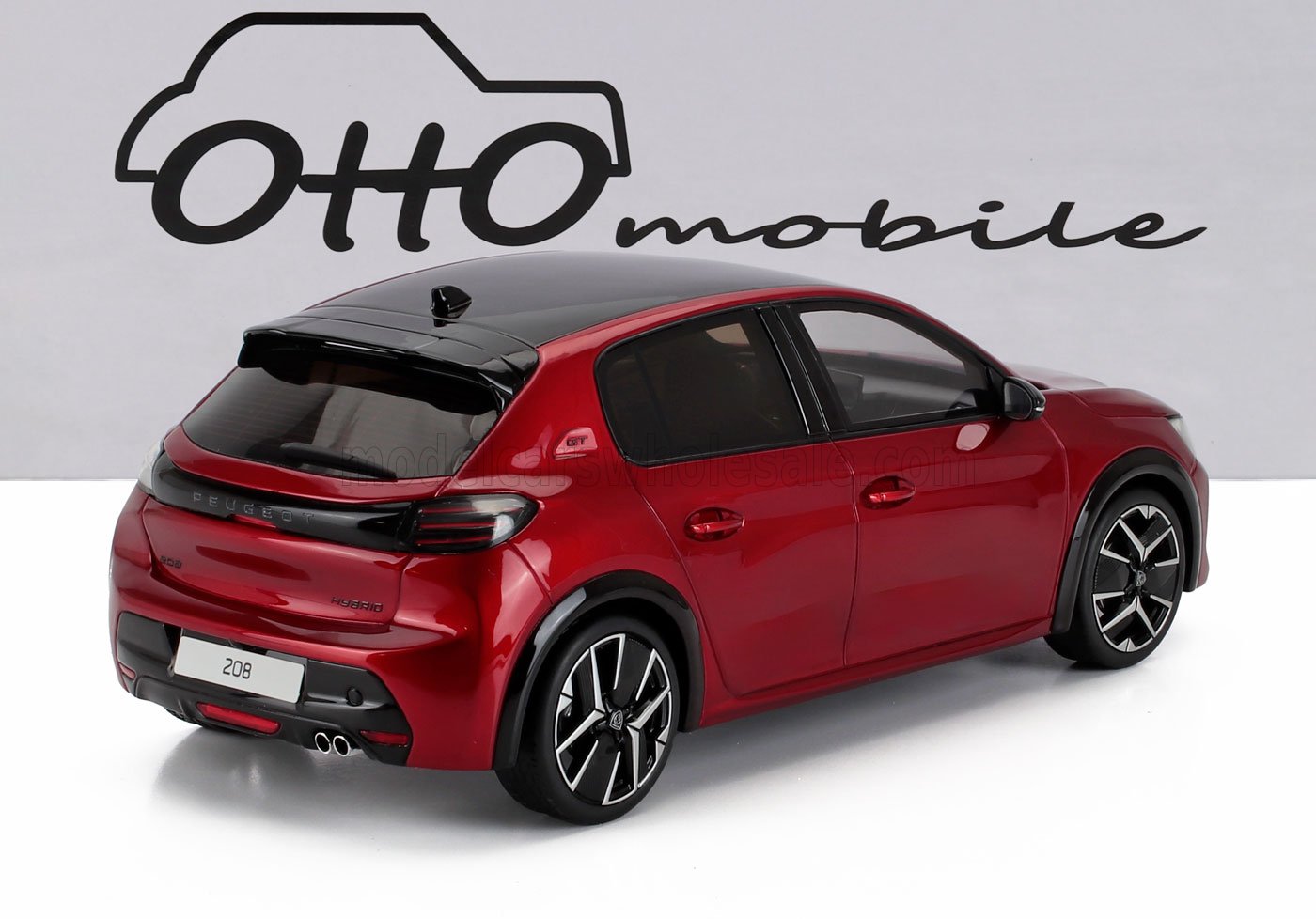 Modellino di Peugeot 208 GT Hybrid rossa con tetto nero su sfondo bianco, ora disponibile su Vroomi.