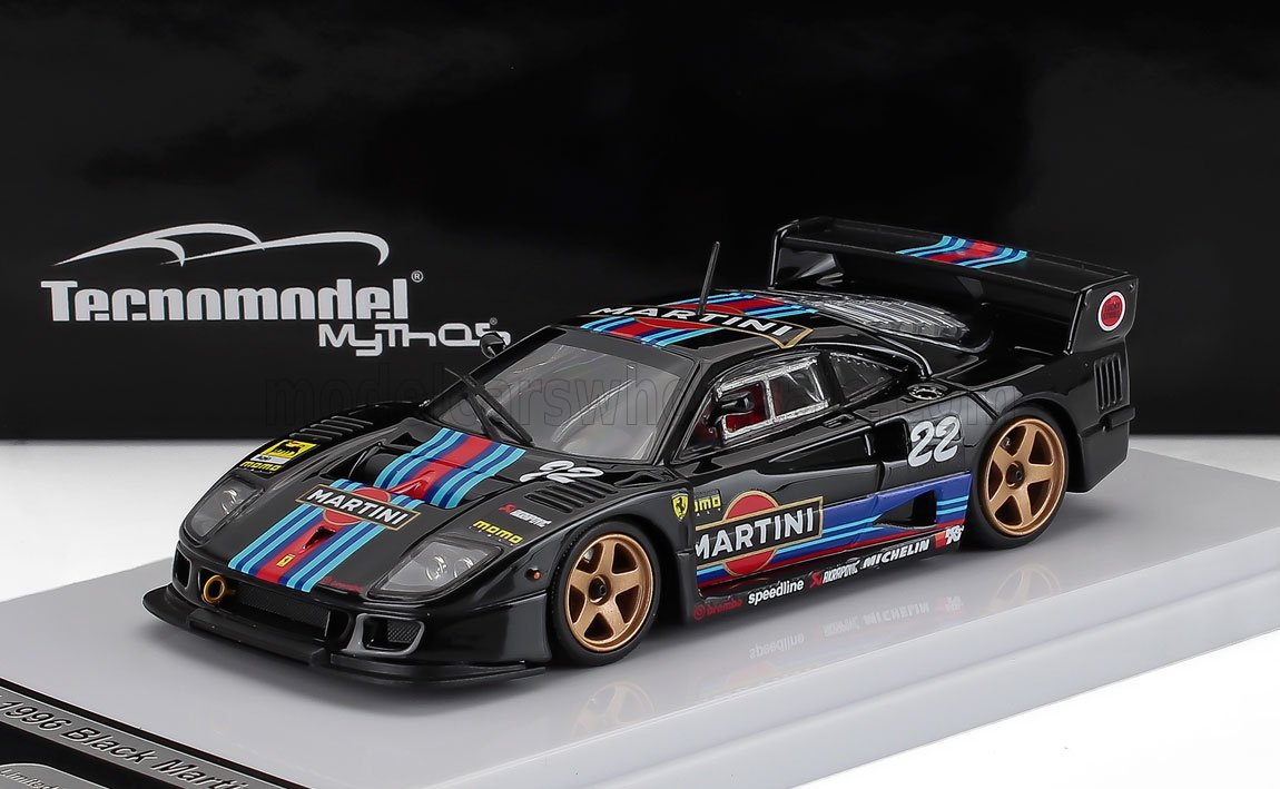 Modellino di auto da corsa Black Martini con strisce blu e rosse, ruote dorate, in esposizione, disponibile tramite Vroomi.