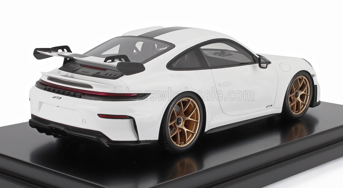 White Porsche 911 GT3 model car with gold wheels and rear wing on display, available on Vroomi