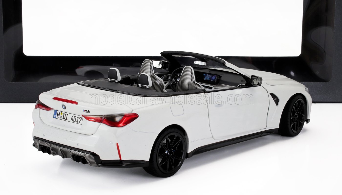 Modellino di BMW M4 cabrio bianca con sedili in fibra di carbonio e cerchi neri, disponibile su Vroomi.