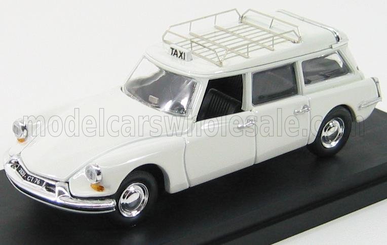 Modello di taxi station wagon vintage bianco con portapacchi sul supporto espositivo, disponibile su Vroomi.