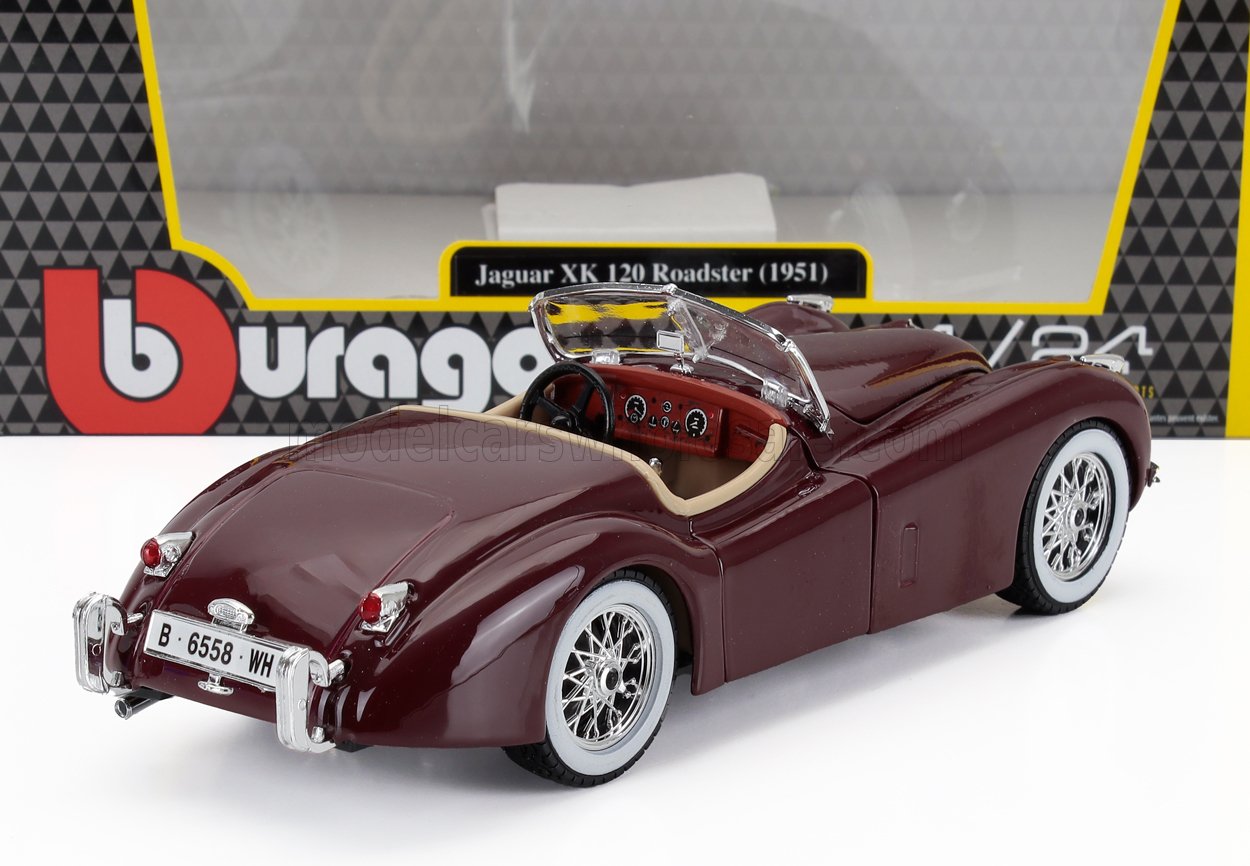 Modellino di auto Jaguar 120 Roadster del 1951 color bordeaux con pneumatici a fascia bianca, esposto con scatola Burago, disponibile tramite Vroomi.