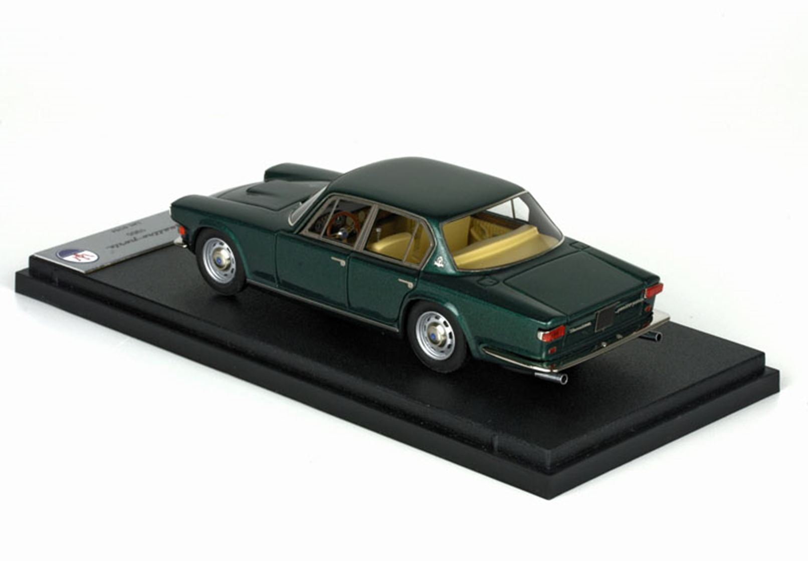 Modellino d'auto vintage verde scuro con interni color cuoio su base espositiva nera, disponibile tramite Vroomi.