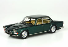 Modello di auto classica a quattro porte verde scuro con interni beige, mostrato su sfondo bianco, disponibile su Vroomi.