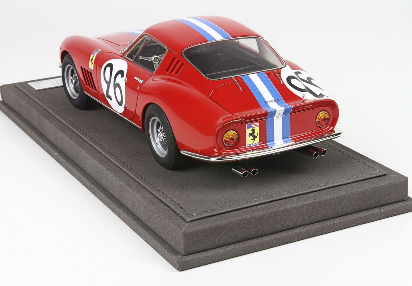 Modellino vintage rosso di una Ferrari da corsa con il numero 26 e strisce blu e bianche su un espositore, in vendita su Vroomi.