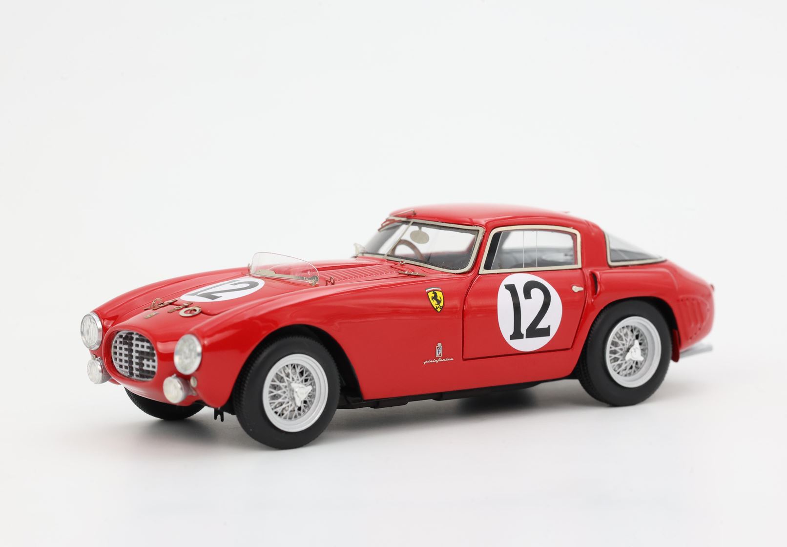 Red vintage Ferrari race car model with number 12, detailed wheels, and Pininfarina emblem, purchasable on Vroomi
