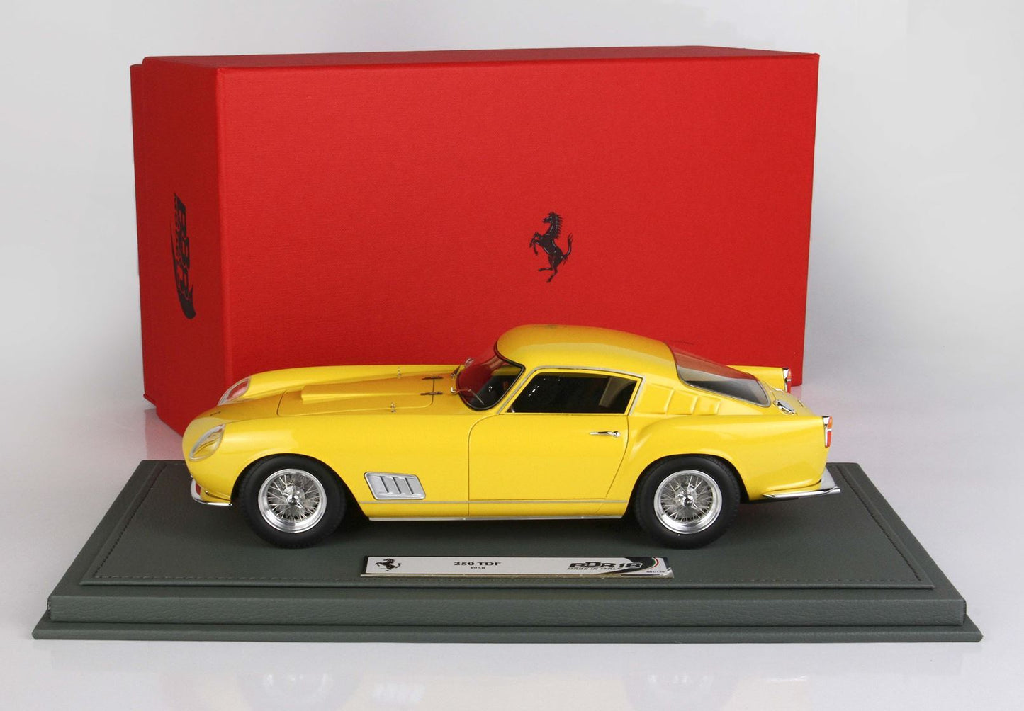 Modellino di Ferrari 250 TDF giallo su espositore con scatola Ferrari rossa, disponibile tramite Vroomi