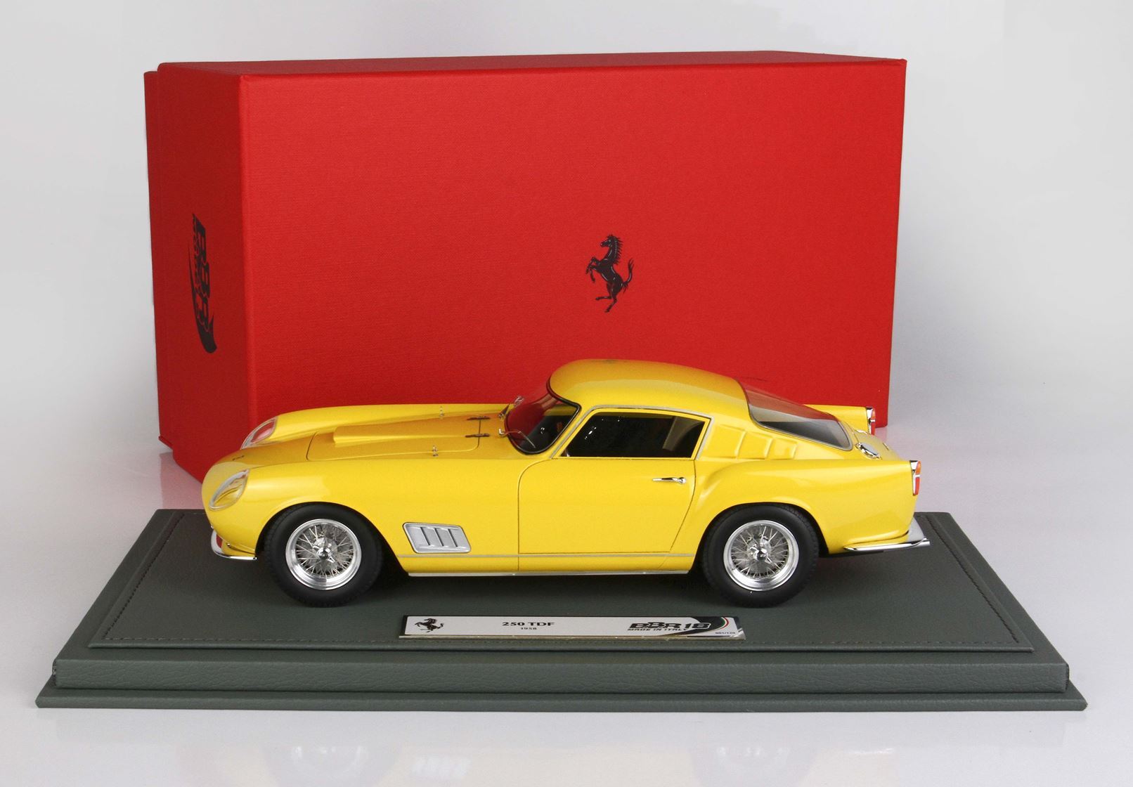 Modellino di Ferrari 250 TDF giallo su espositore con scatola Ferrari rossa, disponibile tramite Vroomi