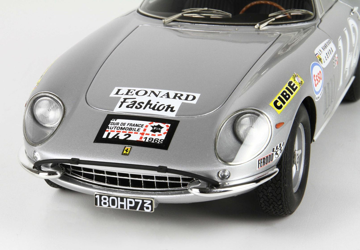Modellino classico in argento di un'auto da corsa Ferrari con adesivi vintage e targa 180HP73, disponibile su Vroomi.