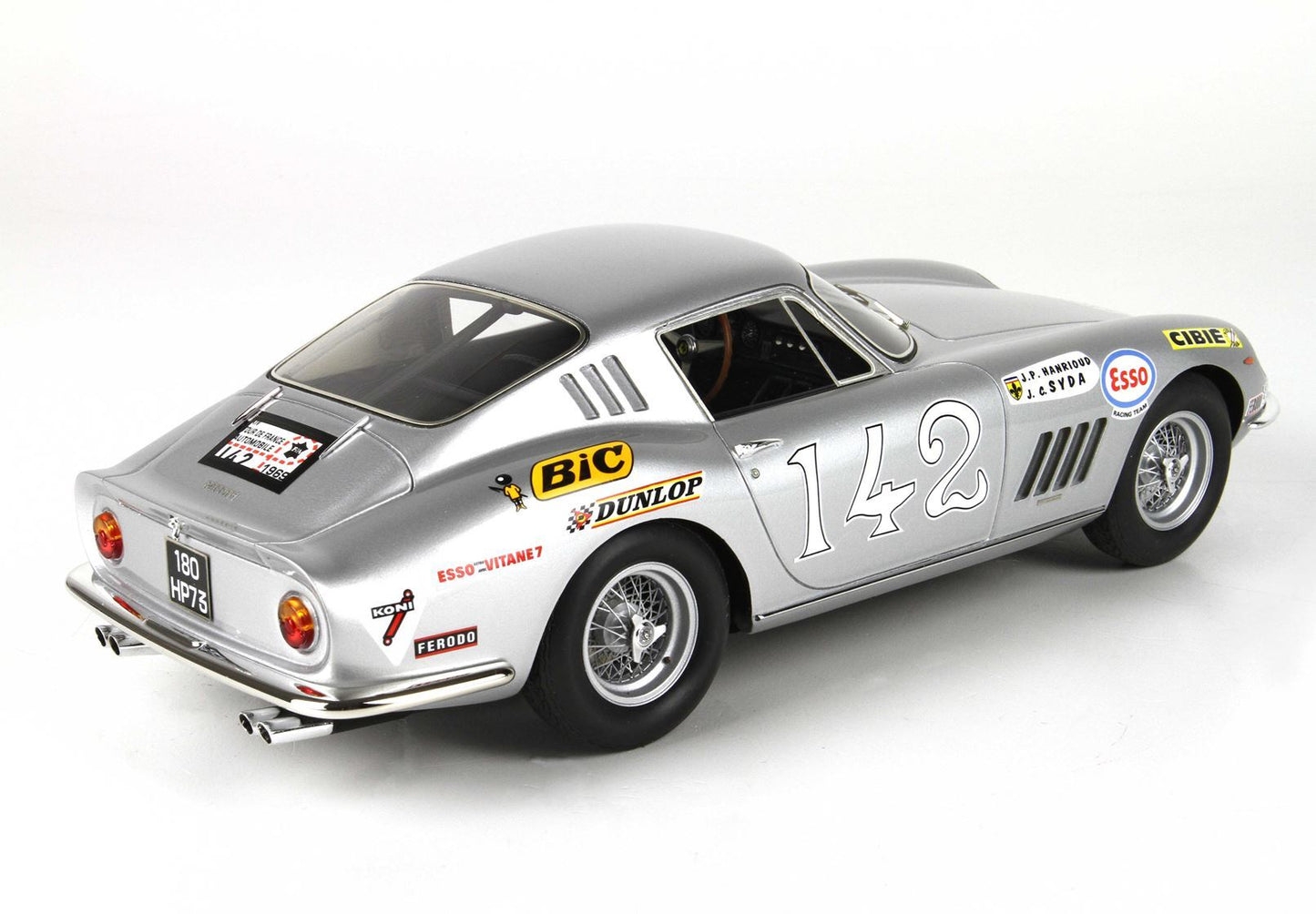 Auto da corsa vintage color argento con il numero 142 e adesivi degli sponsor, apparsa su Vroomi.