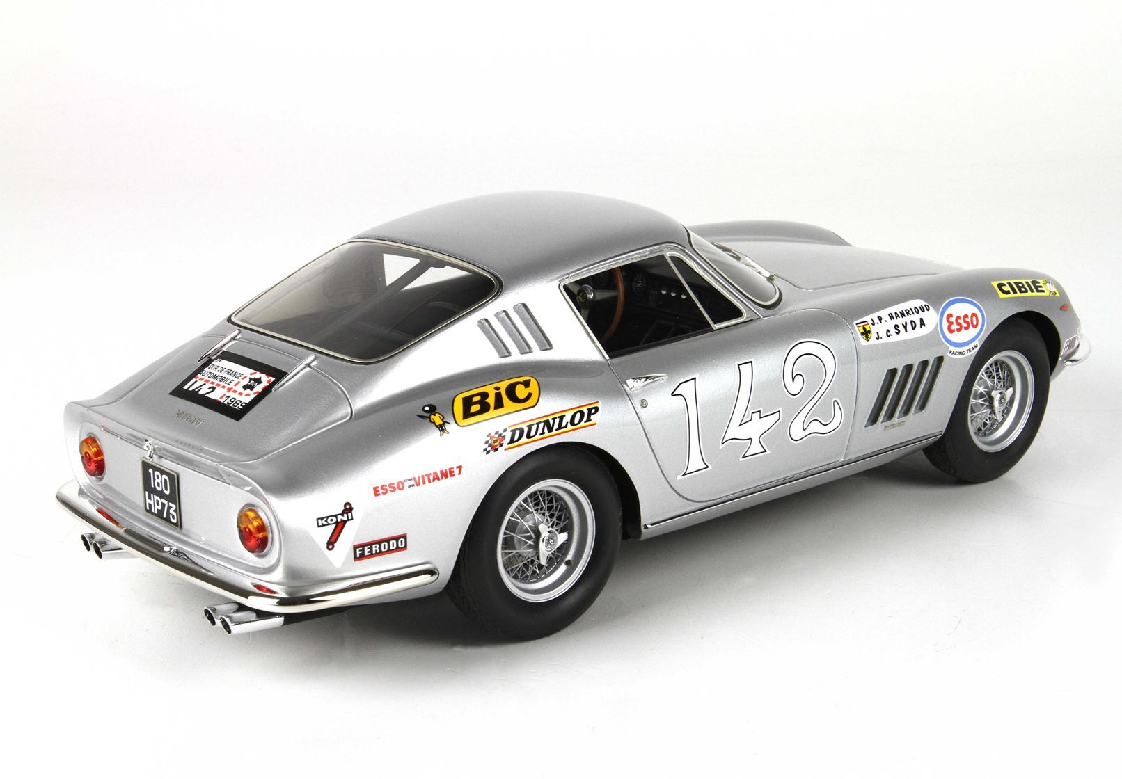 Auto da corsa vintage color argento con il numero 142 e adesivi degli sponsor, apparsa su Vroomi.