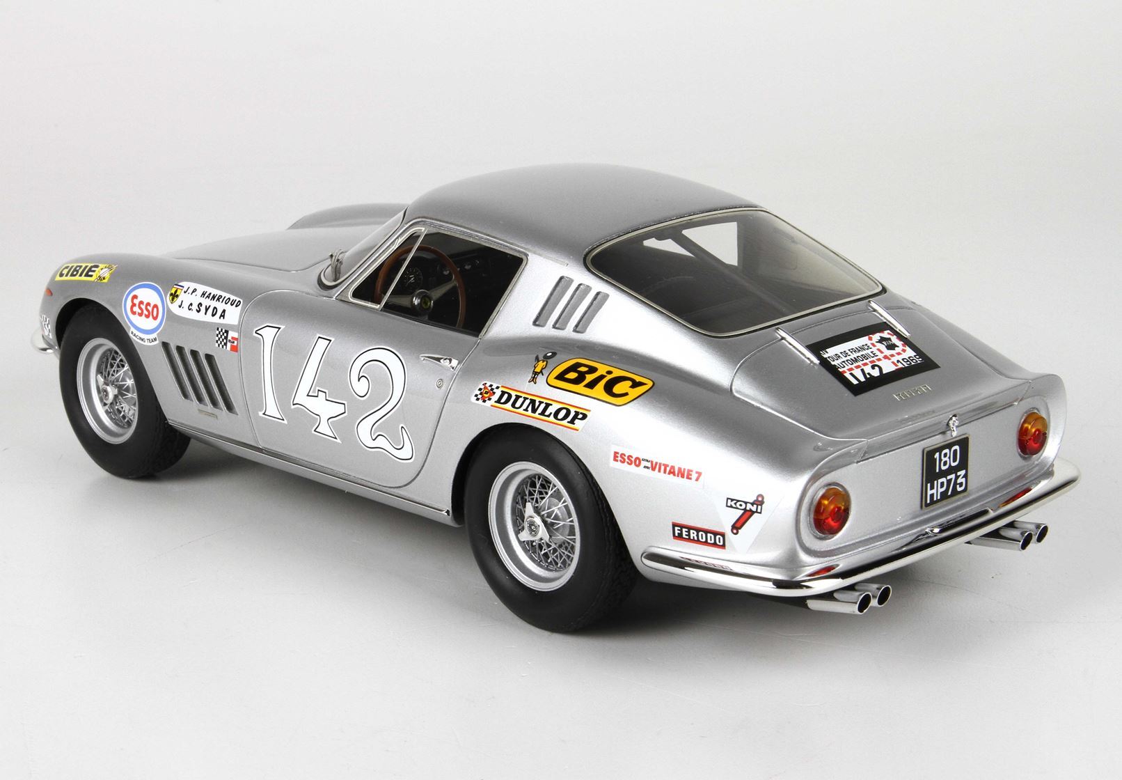 Auto da corsa vintage color argento numero 142 con adesivi degli sponsor, disponibile sulla piattaforma Vroomi.