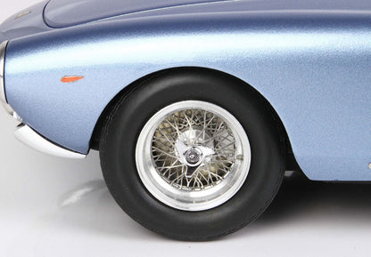 Close-up of blue vintage car front wheel with wire spoke rim and black tire, available on Vroomi