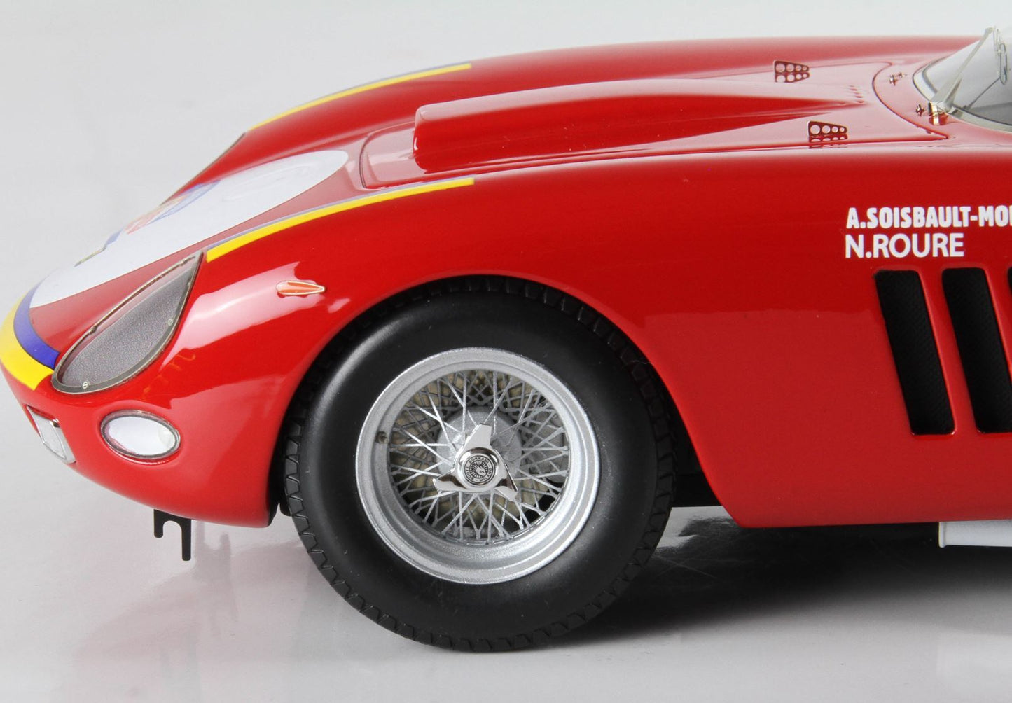 Close-up of red vintage race car front wheel and hood with driver names, available on Vroomi platform