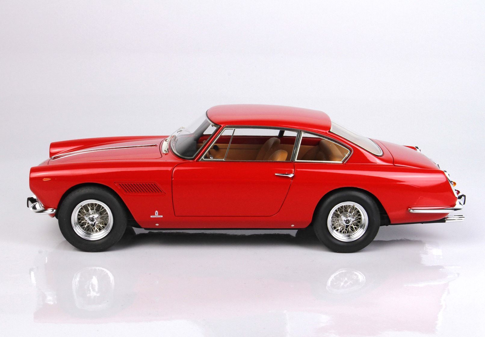 Classic red vintage coupe car with tan interior on white background, available through Vroomi