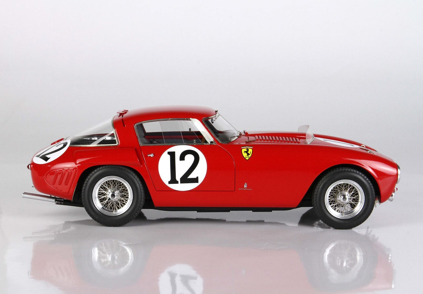Red vintage Ferrari race car with number 12 on sleek body, featured on Vroomi platform