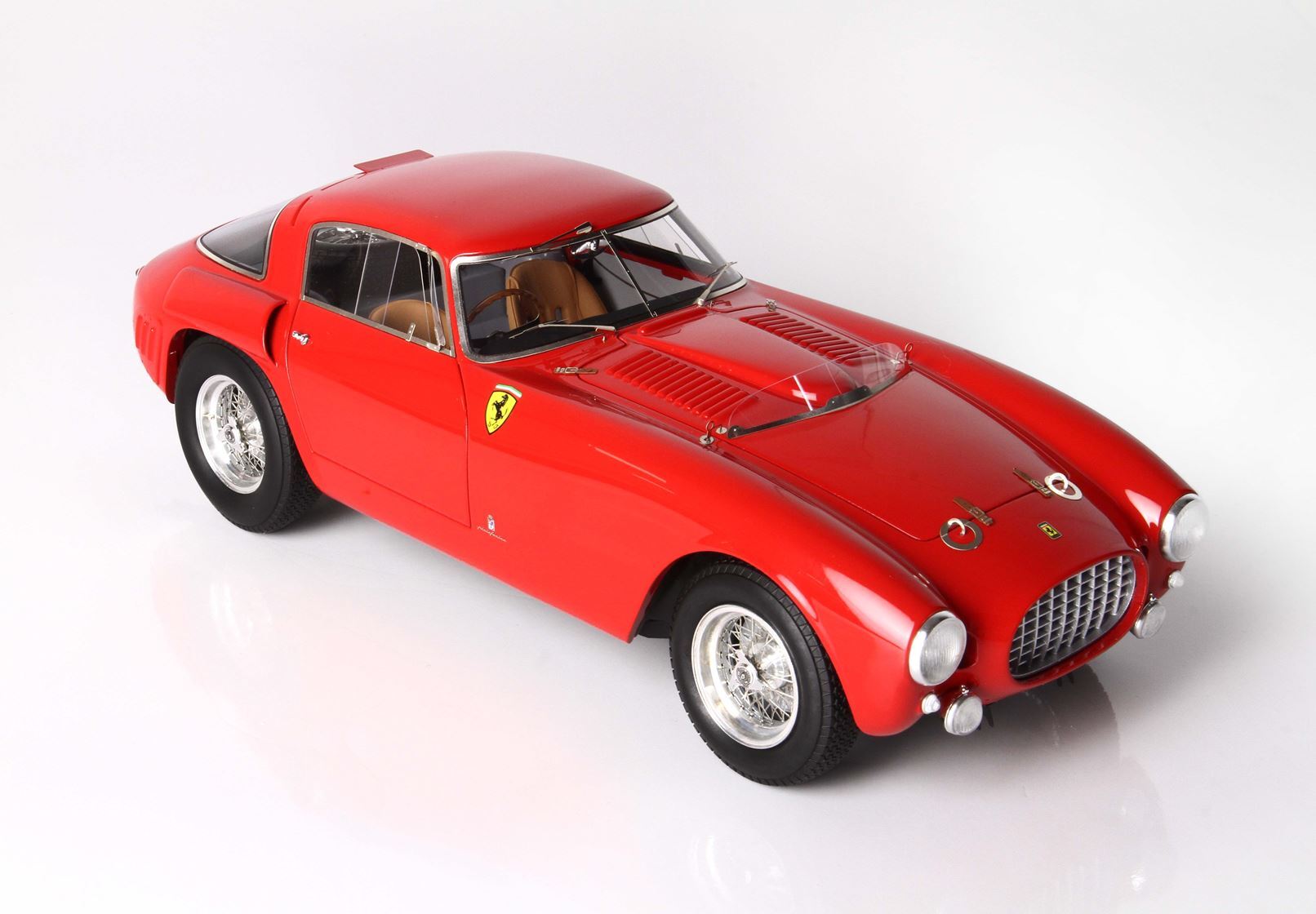 Red classic Ferrari racing car model with tan interior and wire-spoke wheels, offered on Vroomi platform