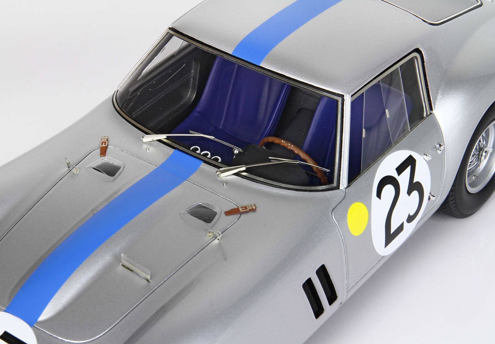 Silver vintage race car with blue stripe number 23, detailed cockpit, available via Vroomi platform