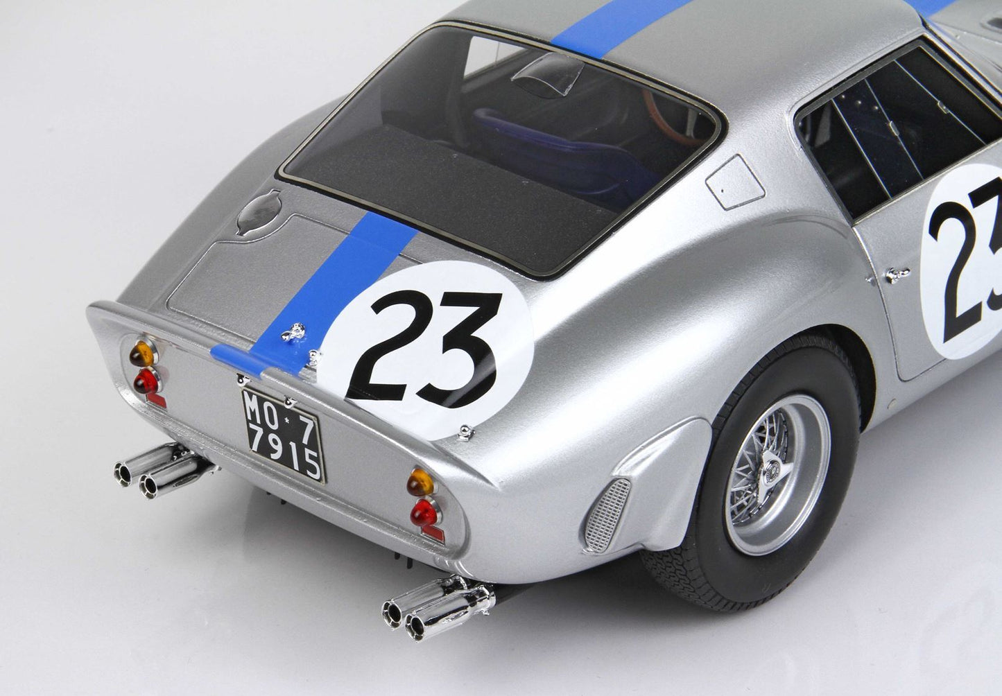 Silver vintage racing car model with blue stripe and number 23, detailed rear view, offered on Vroomi