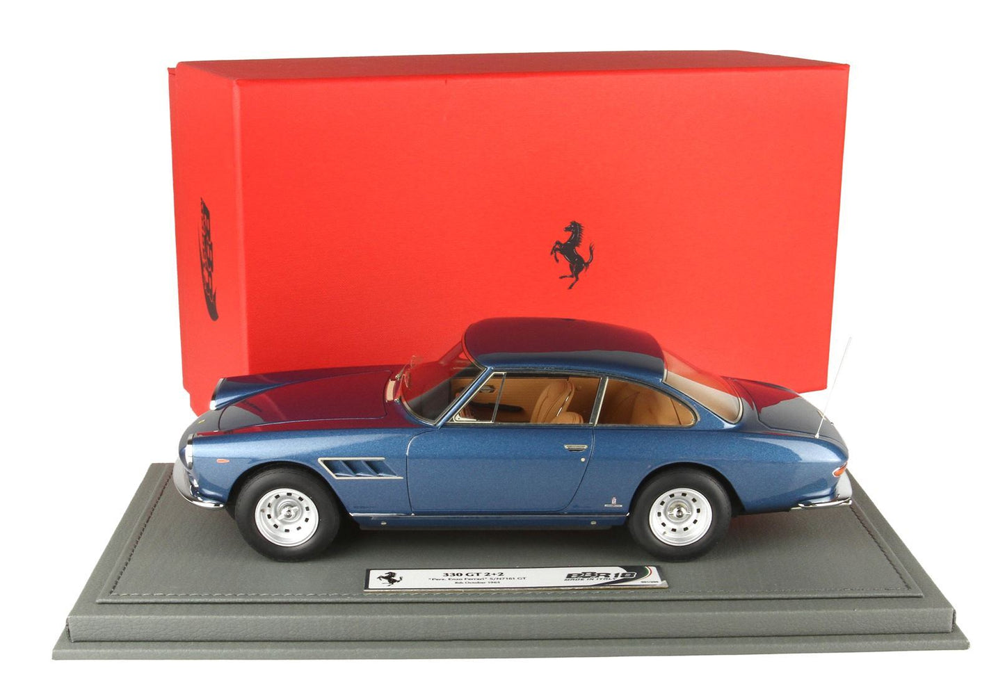 Modellino Ferrari 330 GT 2+2 blu su base grigia con scatola Ferrari rossa, disponibile tramite Vroomi.