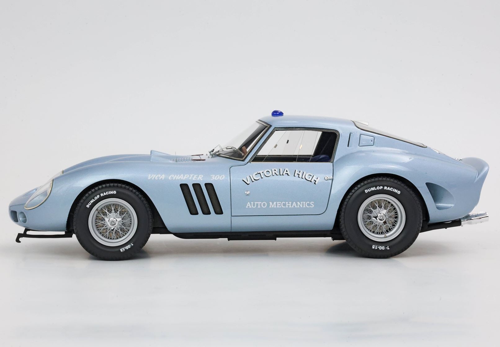 Auto da corsa vintage azzurra con il logo Victoria High Auto Mechanics, pneumatici Dunlop Racing, disponibile su Vroomi.