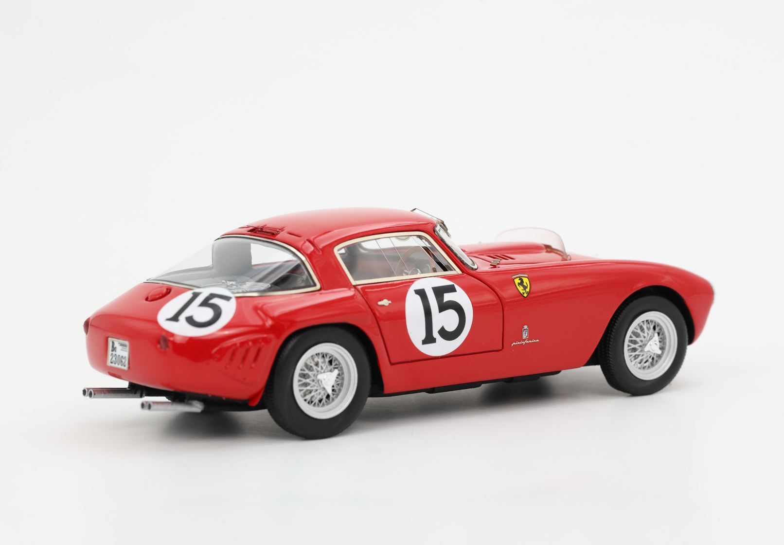 Modellino vintage rosso di una Ferrari da corsa con il numero 15, ruote a raggi super dettagliate, disponibile su Vroomi.