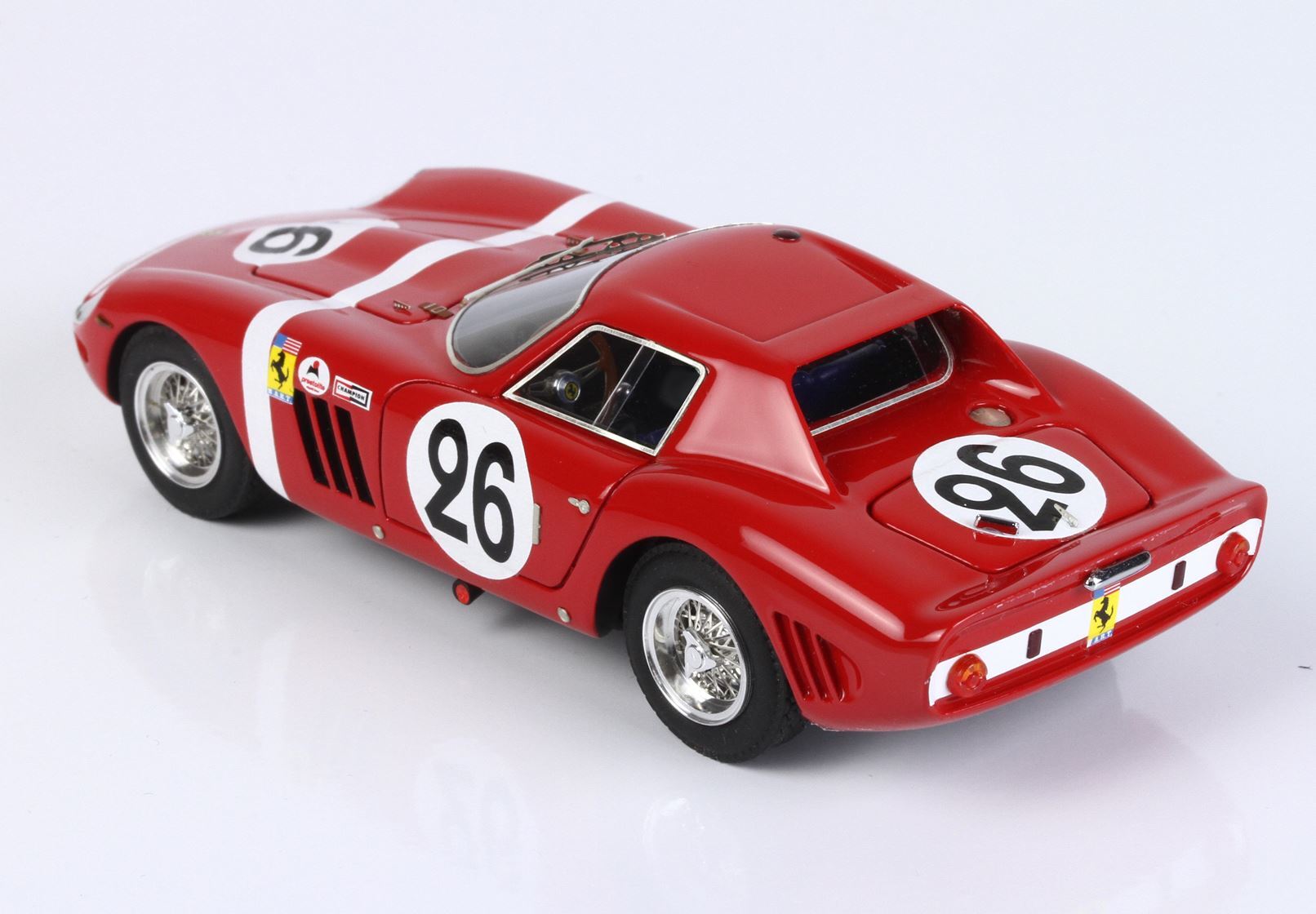 Modellino vintage di un'auto da corsa Ferrari rossa con il numero 26 e ruote a raggi, in vendita su Vroomi.