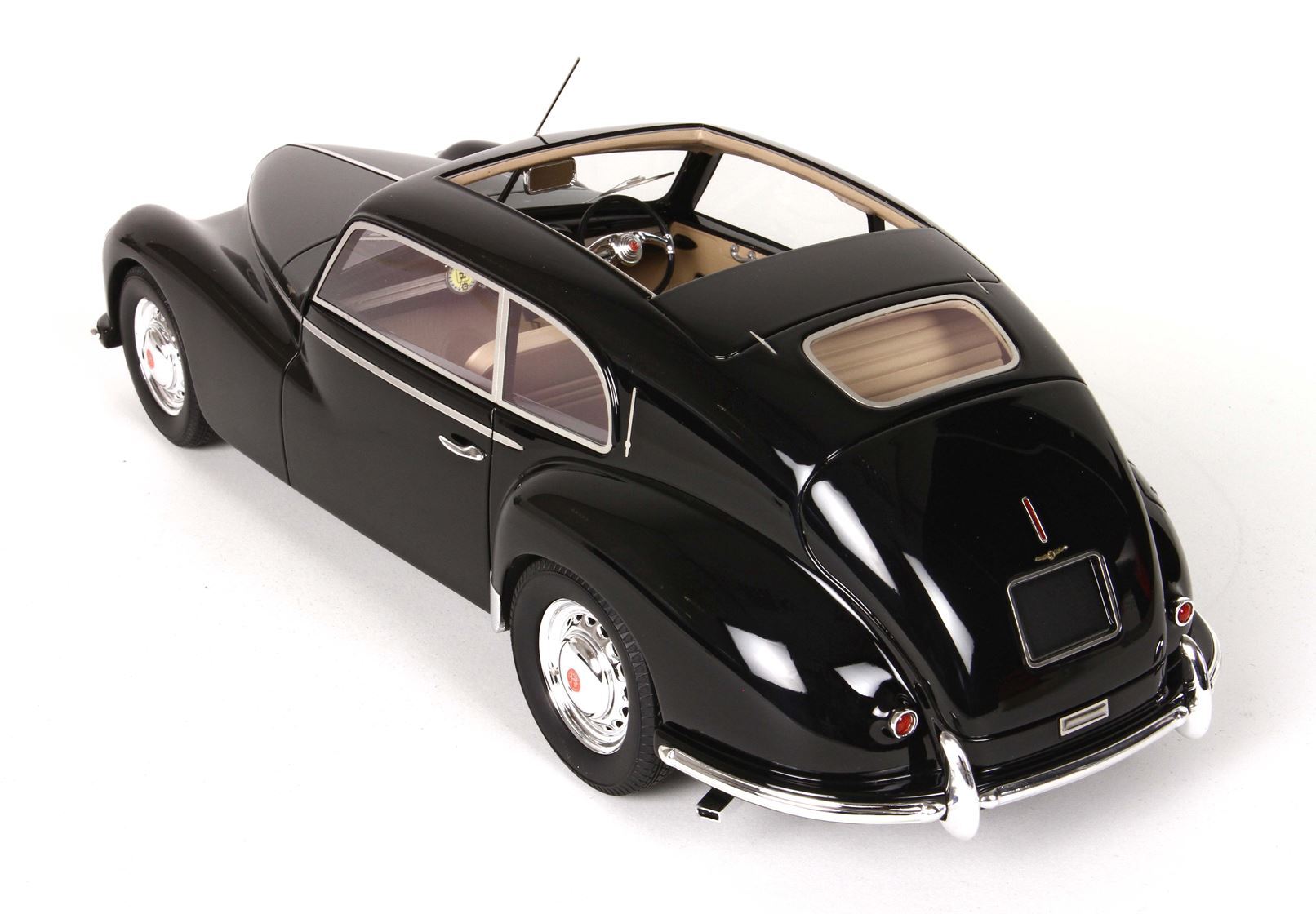 Modello di auto d'epoca classica nera con dettagli cromati e interni beige, disponibile sulla piattaforma Vroomi.