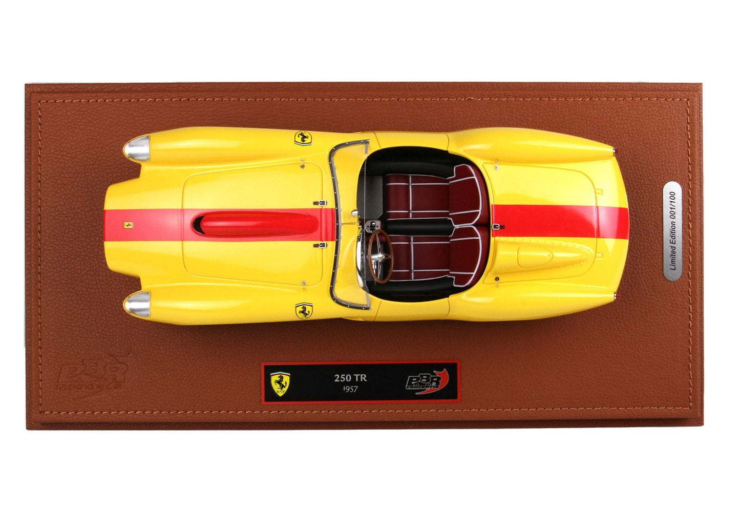 Vista dall'alto dell'auto modellino Ferrari 250 TR 1957 gialla e rossa su base in pelle marrone, edizione limitata, disponibile su Vroomi.