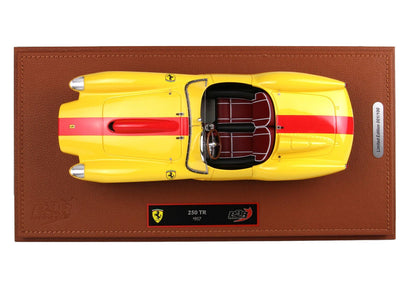 Vista dall'alto dell'auto modellino Ferrari 250 TR 1957 gialla e rossa su base in pelle marrone, edizione limitata, disponibile su Vroomi.