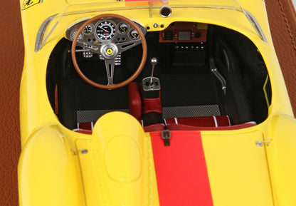 Vista interna dettagliata di un modellino vintage giallo di una Ferrari da corsa con volante in legno e sedili a strisce rosse, in vendita su Vroomi.
