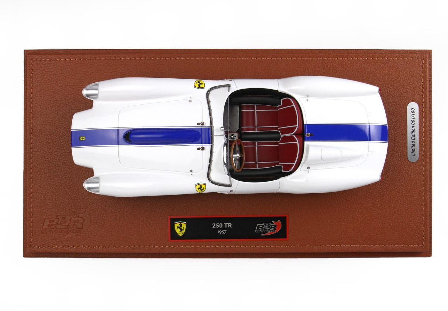 Vista dall'alto di una Ferrari 250 TR del 1957 bianca con striscia blu, interni rossi, esposta su una base in pelle marrone, edizione limitata, disponibile su Vroomi.