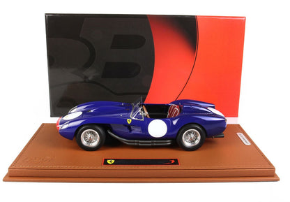 Modellino dettagliato di Ferrari blu su base in pelle marrone con sfondo nero e rosso, disponibile tramite Vroomi.